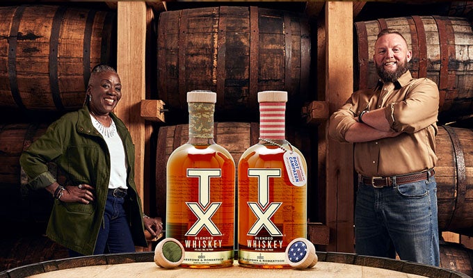 Cassie and Jason standing behind 2 TX Whiskey bottles 